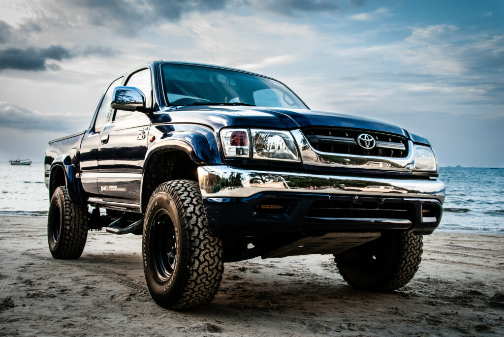 Blue Toyota Hilux on Sandy Beach - Stylish Rugged Design Wallpaper
