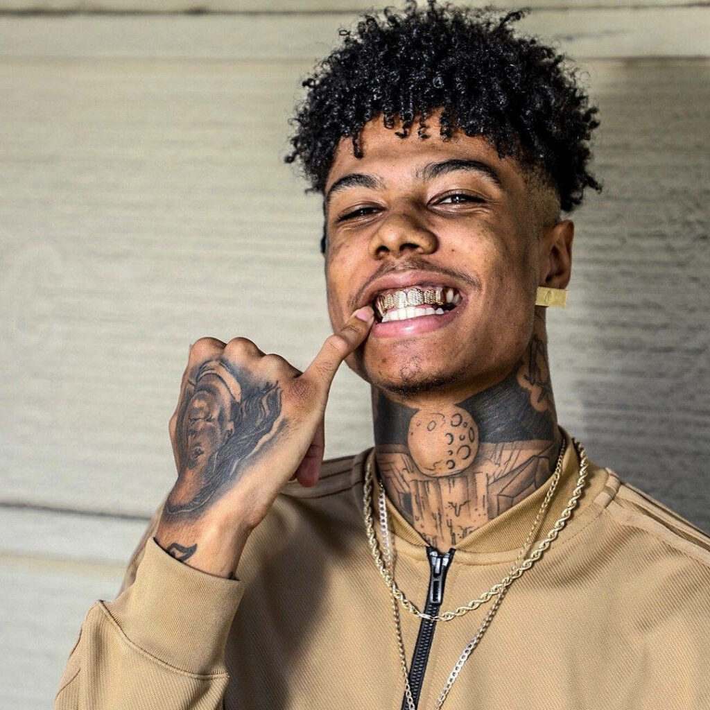Blueface smiling with diamond grill and signature tattoos vibrant wallpaper background style