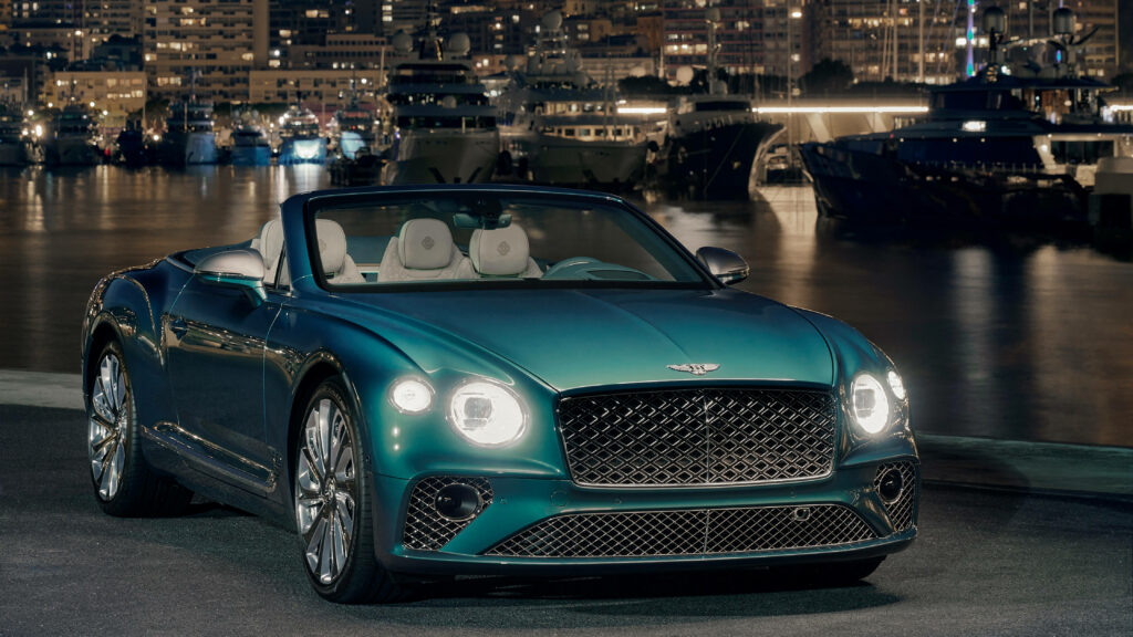 Portside Luxury: Stunning 4K Image Showcasing a Bluish-Green Bentley Continental GT V8 Surrounded by Scenic Waters and Urban Charm Wallpaper