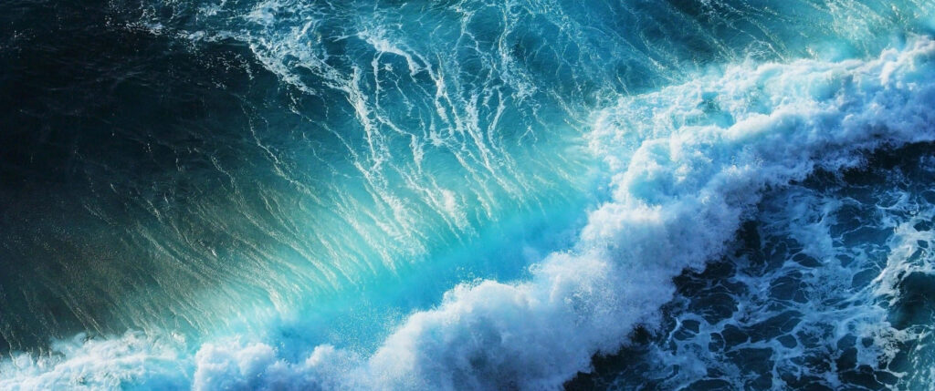 Bluish Green Marvel: Captivating Ultra Wide Shot of Nature's Waves Wallpaper