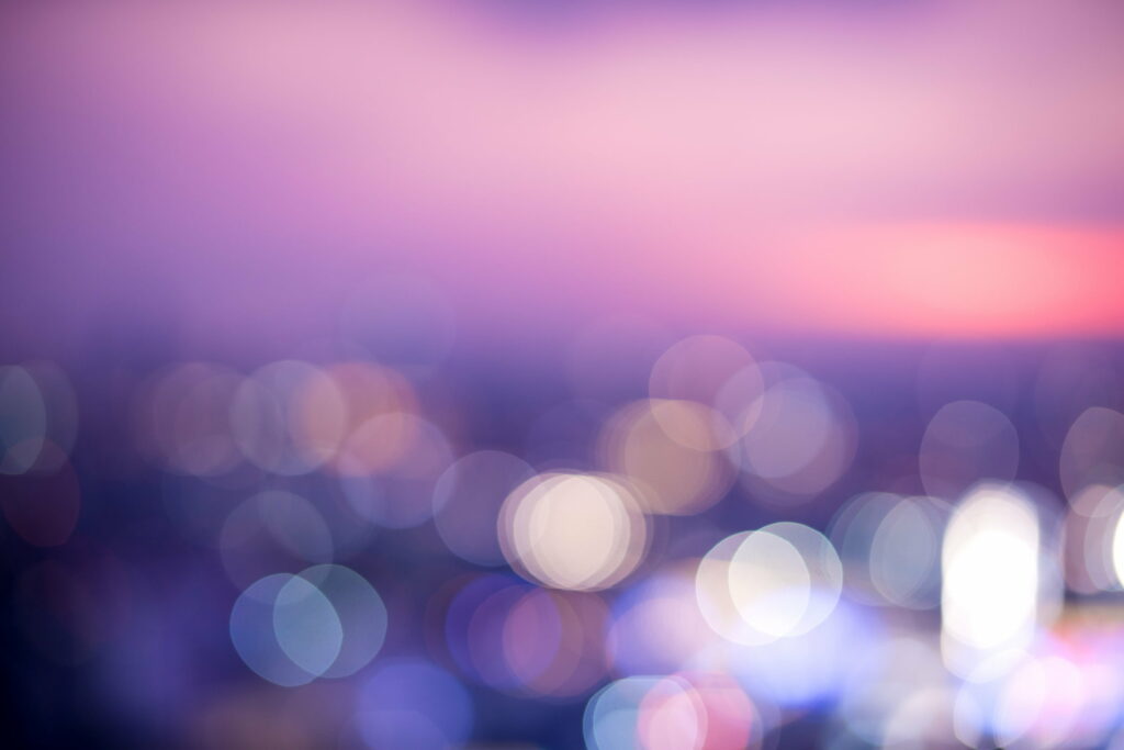 Dreamy blurred bokeh wallpaper with soft purple pink hues and cool urban light accents