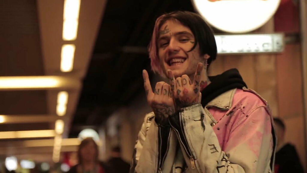 Glowing Lil Peep: Embracing Hand Gestures in a Vibrant, Blurred Light Surrounding, Rocking Unique Sandal Coat Wallpaper