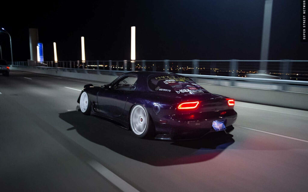 Majestic Mazda Rx-7: Cruising Confidently on a Desolate Urban Canvas Wallpaper