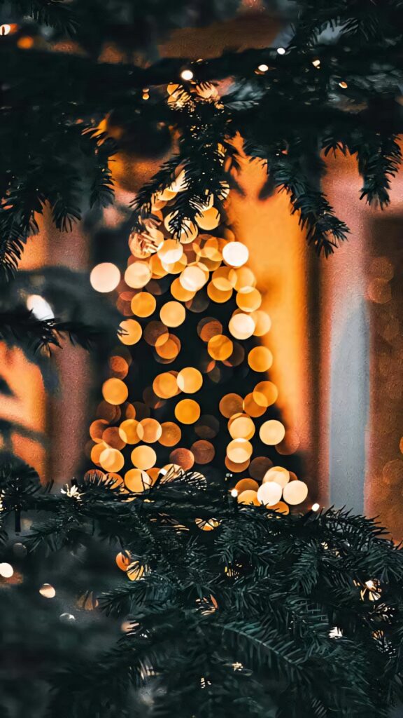 Festive Blurred Christmas Tree Wallpaper with Bokeh Lights Background