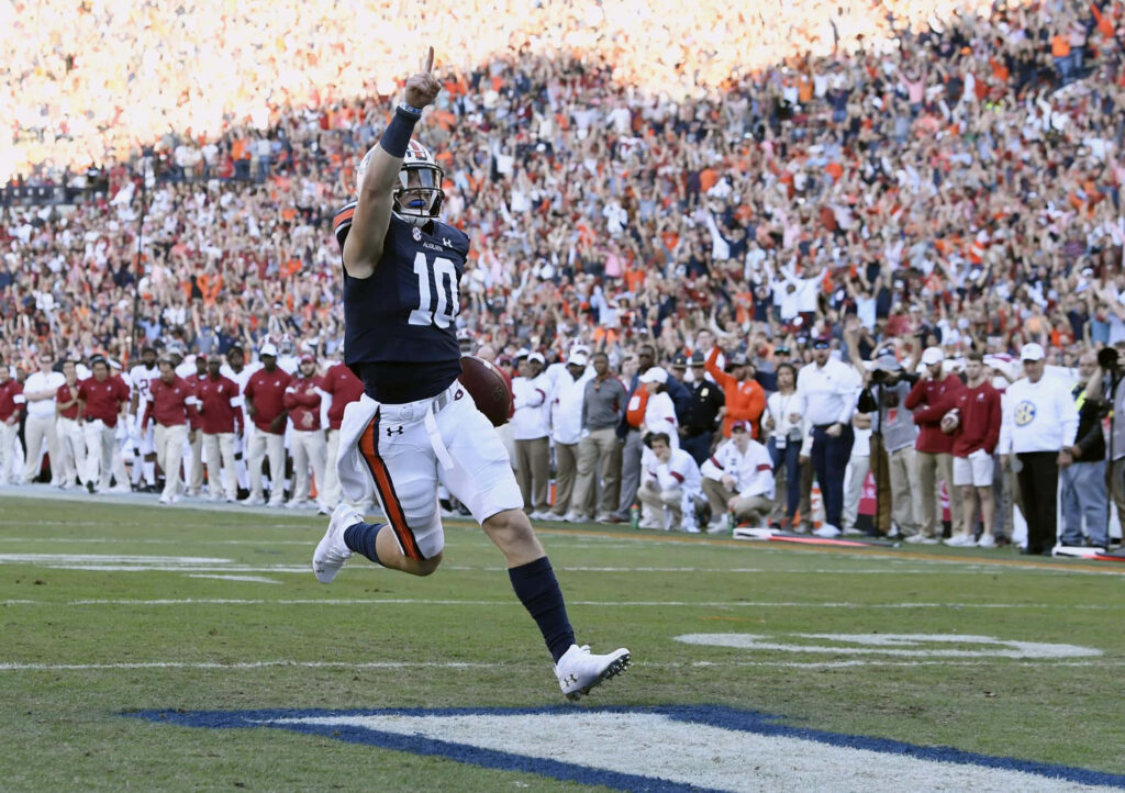 Bo Nix mid-air touchdown celebration football excitement stadium wallpaper background