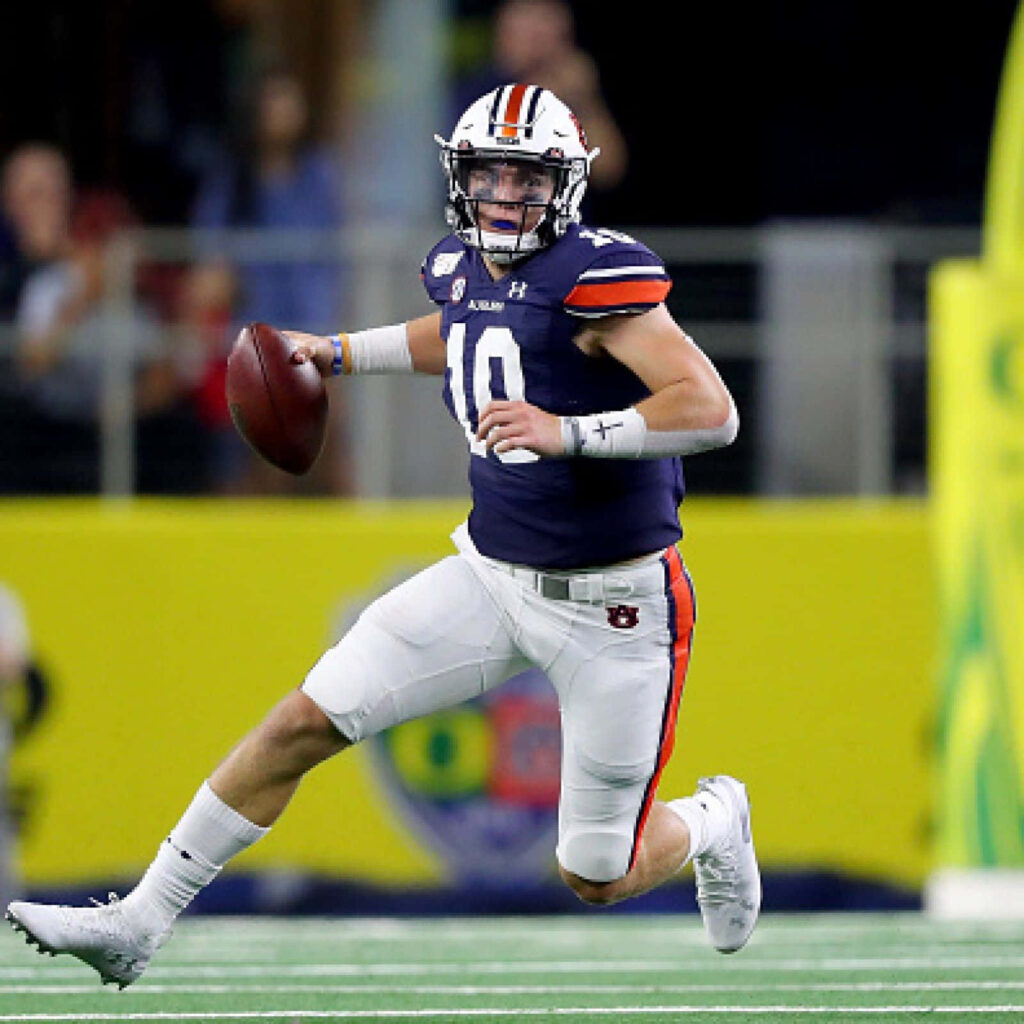 Quarterback Bo Nix in action throwing football showing focus athleticism high stakes game Wallpaper