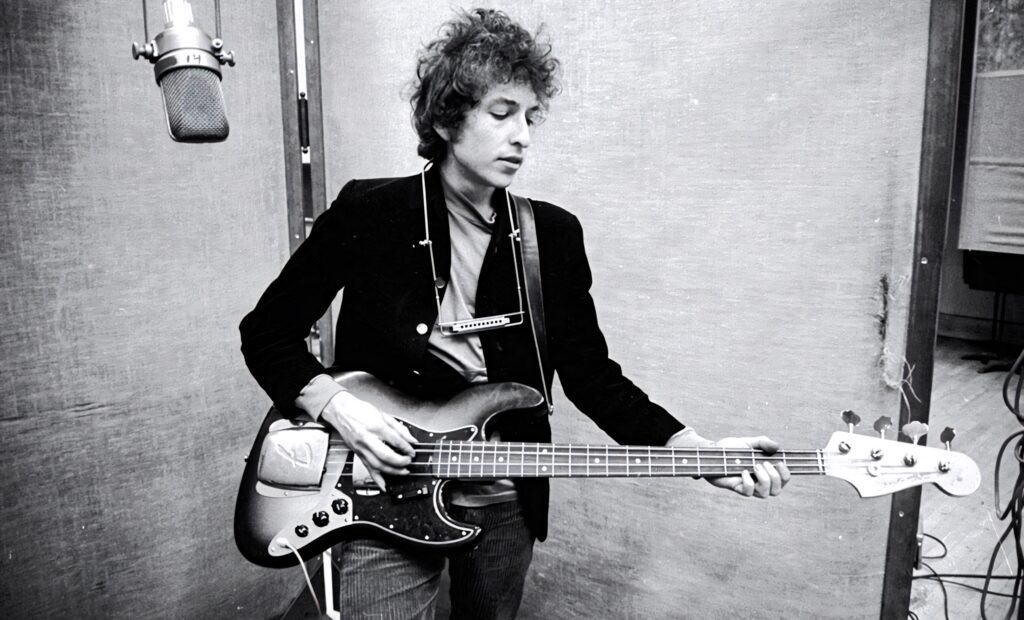 Bob Dylan playing guitar in recording studio iconic singer songwriter classic music wallpaper background