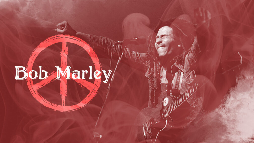 Bob Marley on stage with raised fists smoky red background peace sign and bold name wallpaper