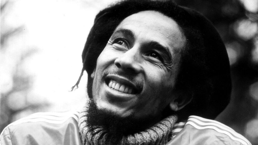 Bob Marley joyful reflection reggae icon wallpaper background featuring The Wailers legend