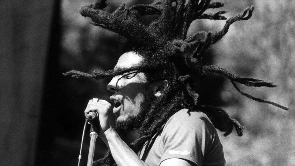 Bob Marley performing live on stage with dreadlocks and microphone reggae music wallpaper