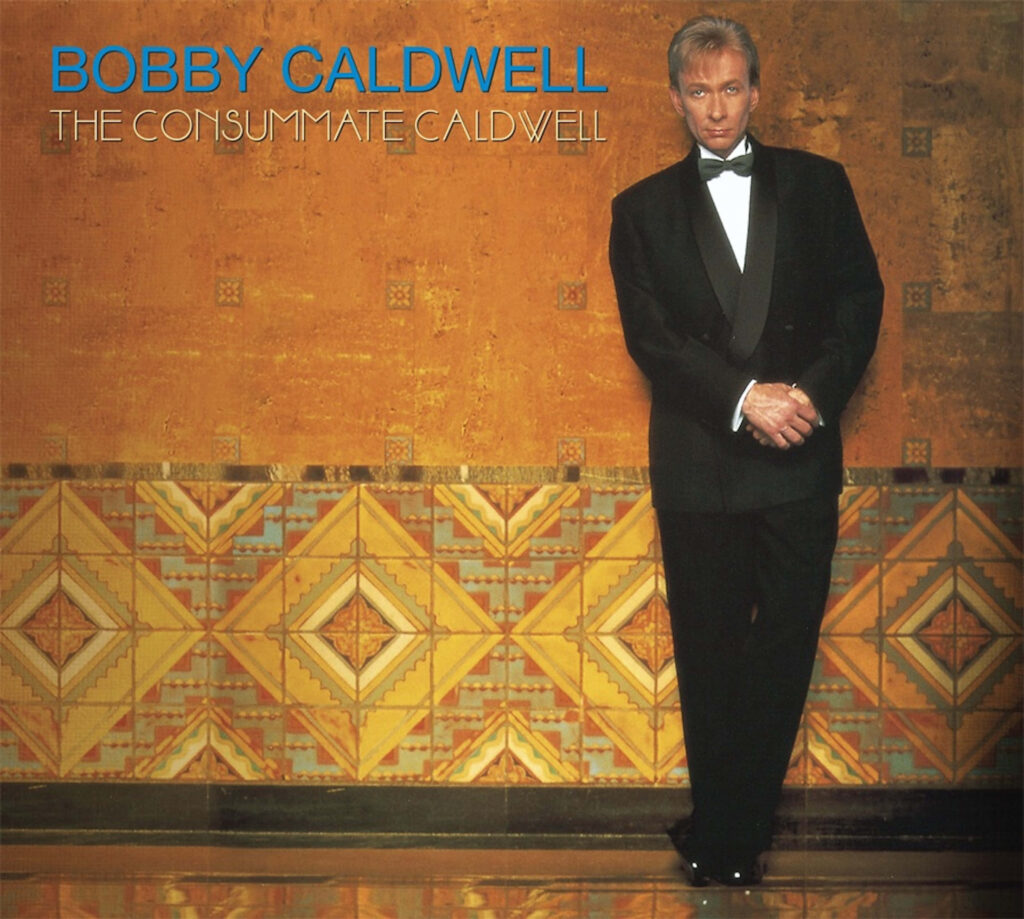 Bobby Caldwell in classic tuxedo against elegant golden patterned backdrop wallpaper background