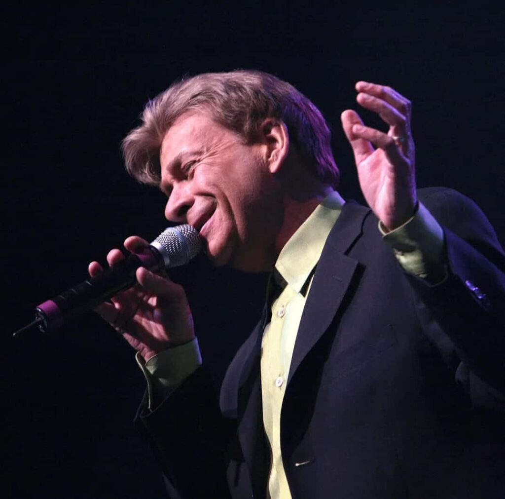 Bobby Caldwell singing live on stage mid-performance with expressive energy and classic style Wallpaper