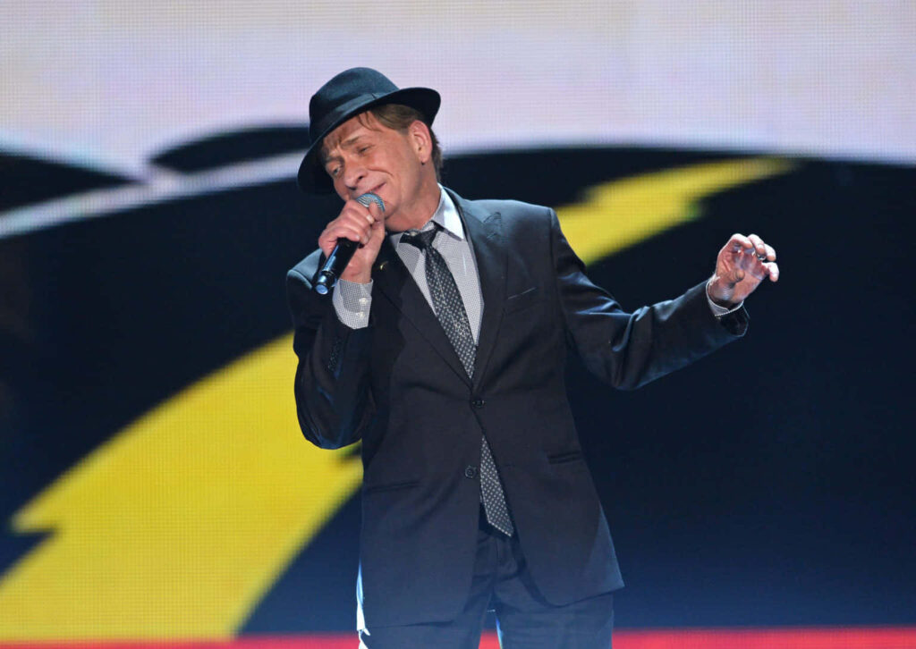 Bobby Caldwell performing live on stage in classic suit and hat with dramatic lighting Wallpaper
