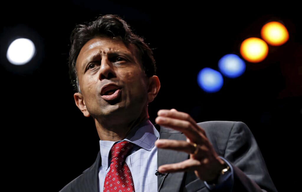 Bobby Jindal speaking passionately mid-gesture with dramatic stage lighting wallpaper background