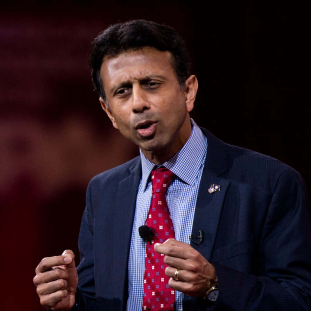 Bobby Jindal speaking at press conference using hand gestures with wallpaper background behind him