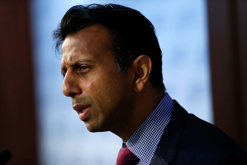 Bobby Jindal speaking passionately during a speech with a blurred wallpaper background