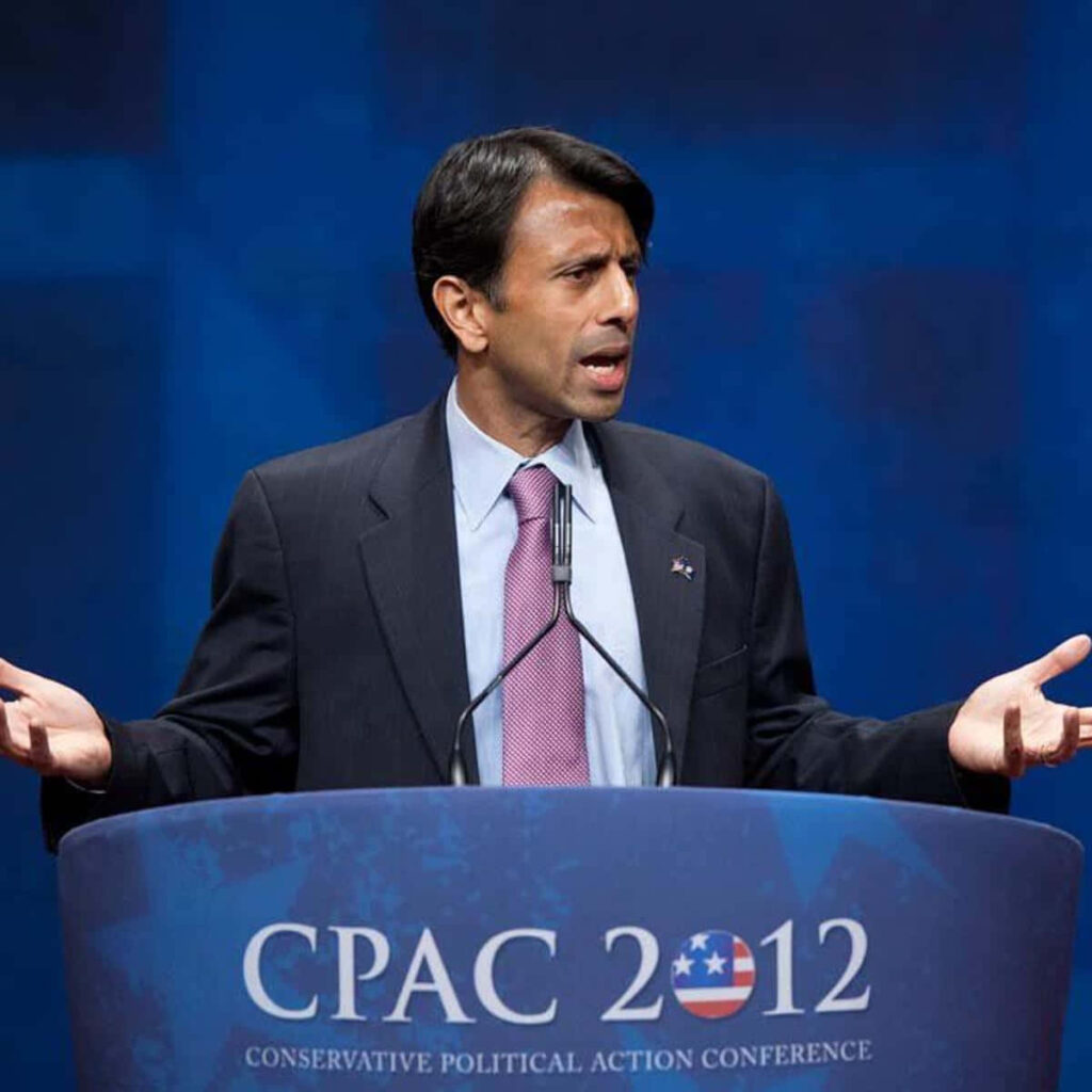 Bobby Jindal speaking at 2012 CPAC conference behind podium with CPAC 2012 logo wallpaper background