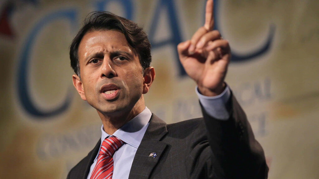 Bobby Jindal speaking and pointing determinedly at CPAC with logo visible in background wallpaper