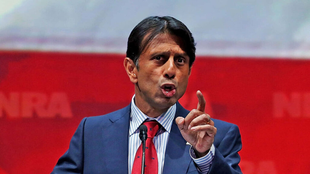 Bobby Jindal speaking passionately at NRA event vibrant red backdrop wallpaper background