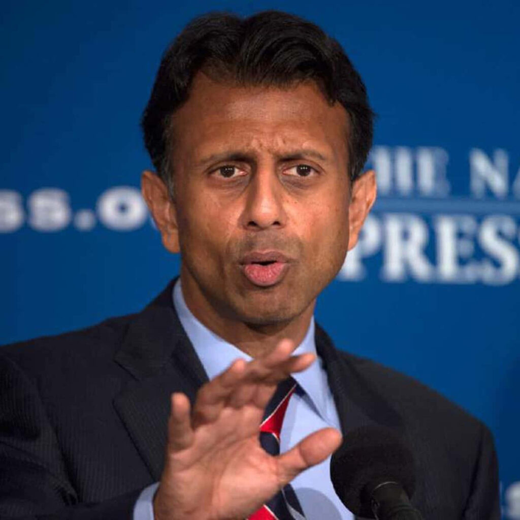 Bobby Jindal speaking at press event gesturing blue backdrop wallpaper background podium