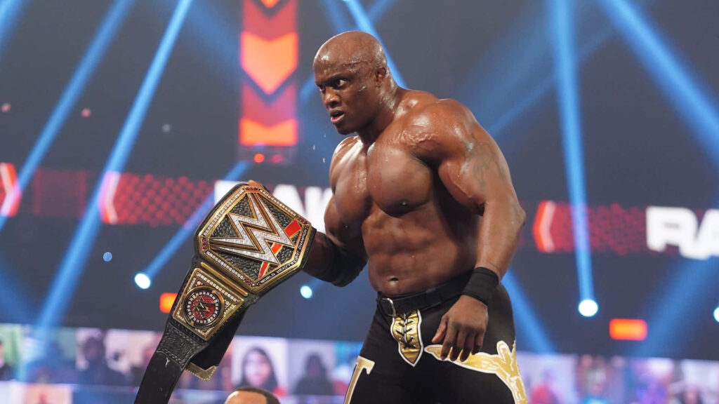 Bobby Lashley celebrating WWE Championship victory holding belt high in wrestling ring wallpaper