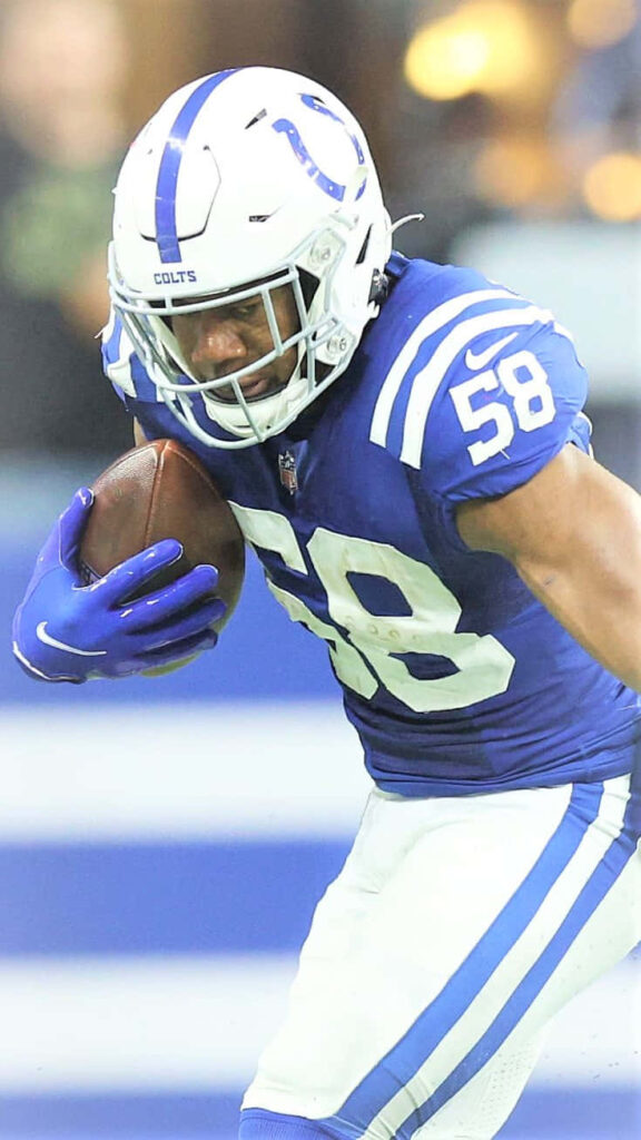 Bobby Okereke intense Colts football player charging down field during NFL game action wallpaper
