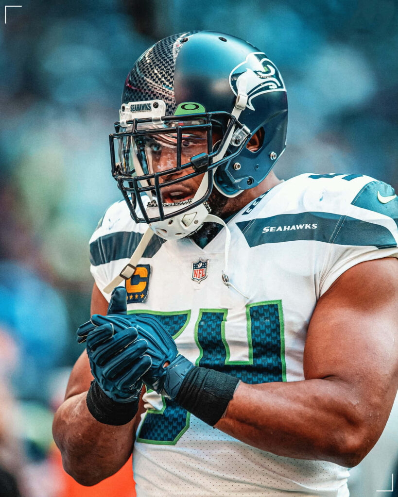 Bobby Wagner focused in Seattle Seahawks gear preparing on field intense football wallpaper background