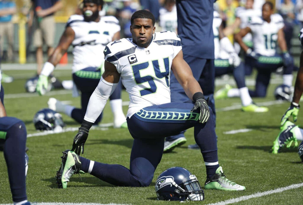 Bobby Wagner in Seattle Seahawks uniform warming up on field before game with wallpaper background