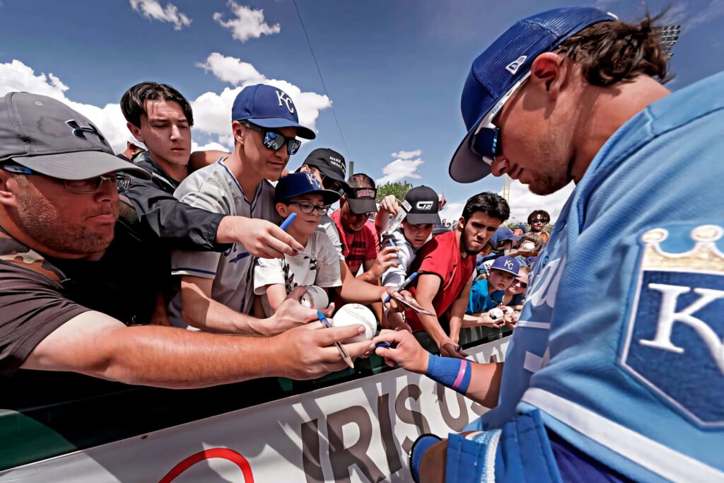 Bobby Witt Jr signing autographs for fans at ballpark vibrant wallpaper background image