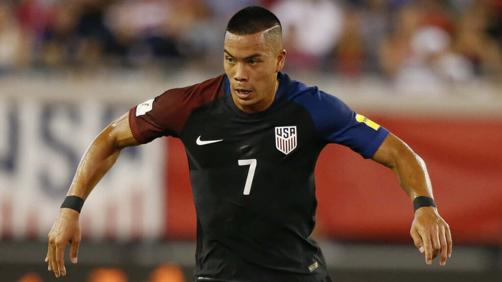 Bobby Wood focused in USA soccer jersey during intense USA versus Honduras match wallpaper background