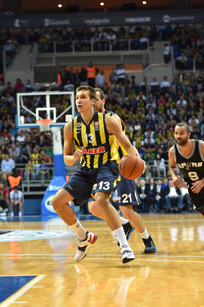 Bogdan Bogdanović driving to the basket in intense basketball game with packed arena background Wallpaper