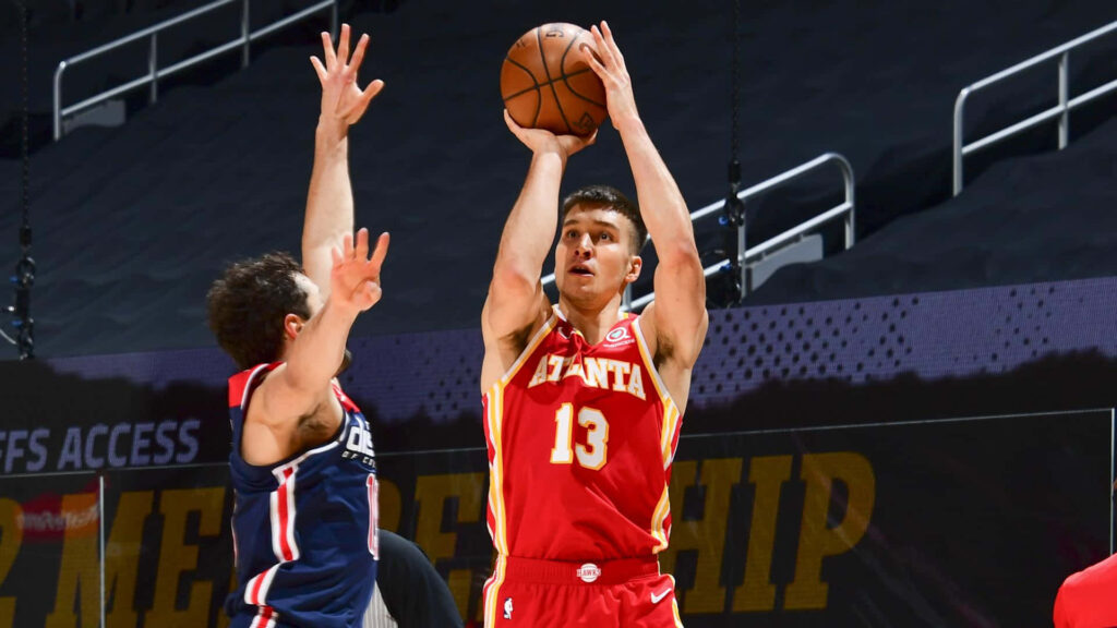 Bogdan Bogdanović shooting a focused jump shot for Atlanta Hawks in intense basketball game background Wallpaper