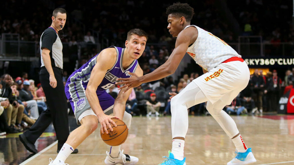 Bogdan Bogdanović defends De'Andre Hunter in intense NBA game action on basketball court wallpaper