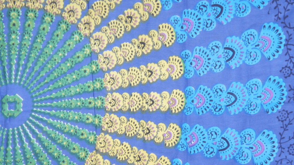 Boho Blue radial wallpaper with cyan green mandala motifs on rich blue fabric background