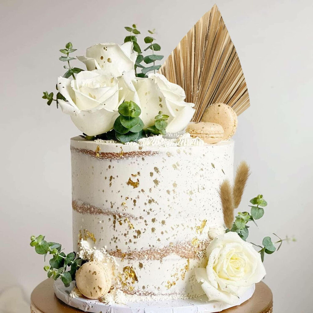 Boho wedding cake wallpaper with semi-naked cake white roses dried palm leaves macarons