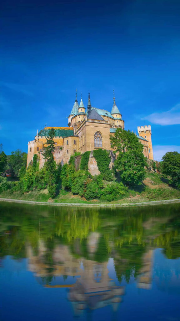 Bojnice Castle medieval reflection in water fairytale architecture Slovakia vibrant greenery Wallpaper
