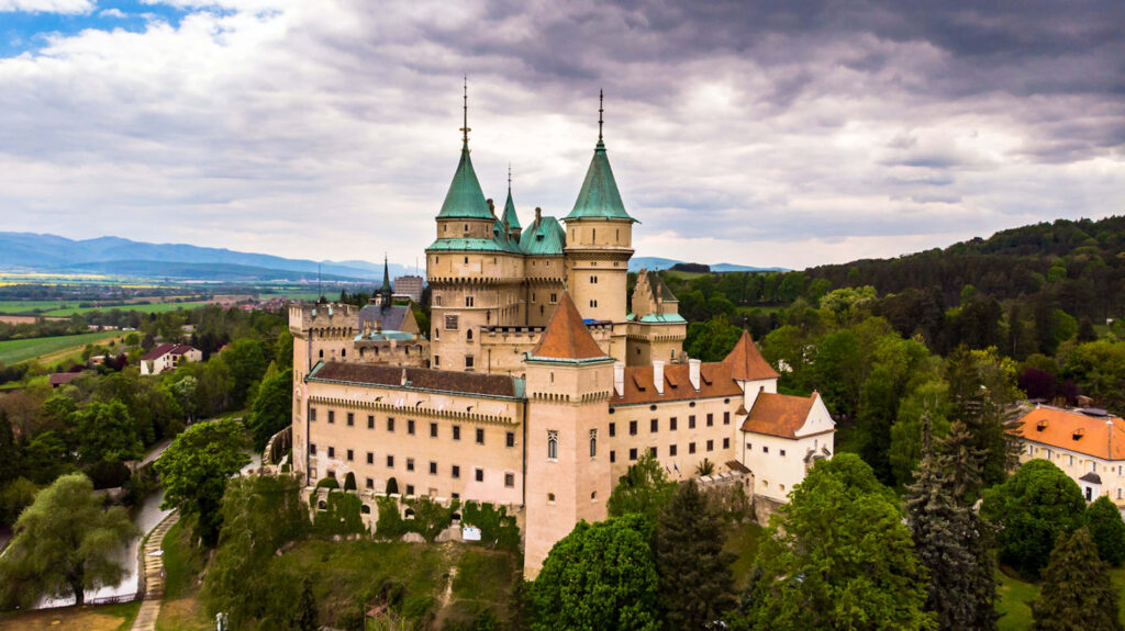 Bojnice Castle medieval fortress in Slovakia surrounded by lush greenery under blue sky Wallpaper