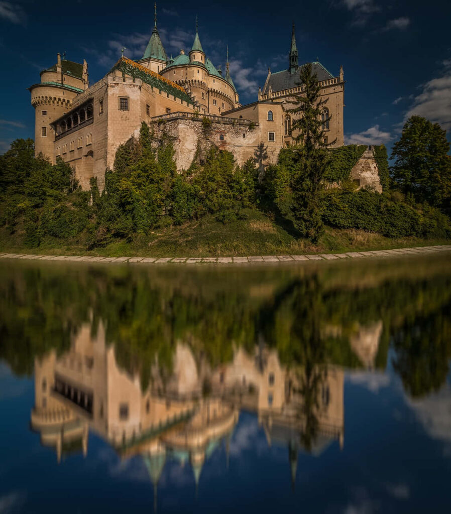 Bojnice Castle medieval fairytale turrets reflection in tranquil moat Slovakia wallpaper background
