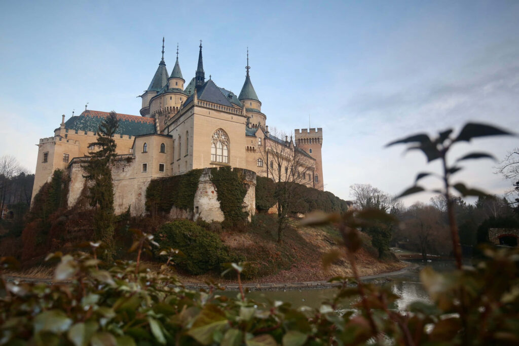 Bojnice Castle view from below with ivy covered walls lush greenery and medieval stone turrets Wallpaper