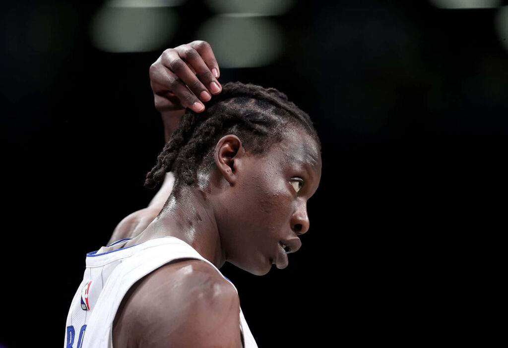 Bol Bol profile wallpaper high resolution basketball player braided hair intense dark background