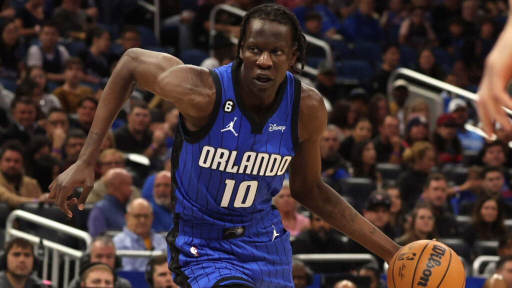 Bol Bol in blue Orlando Magic jersey dribbling basketball during intense game day action wallpaper