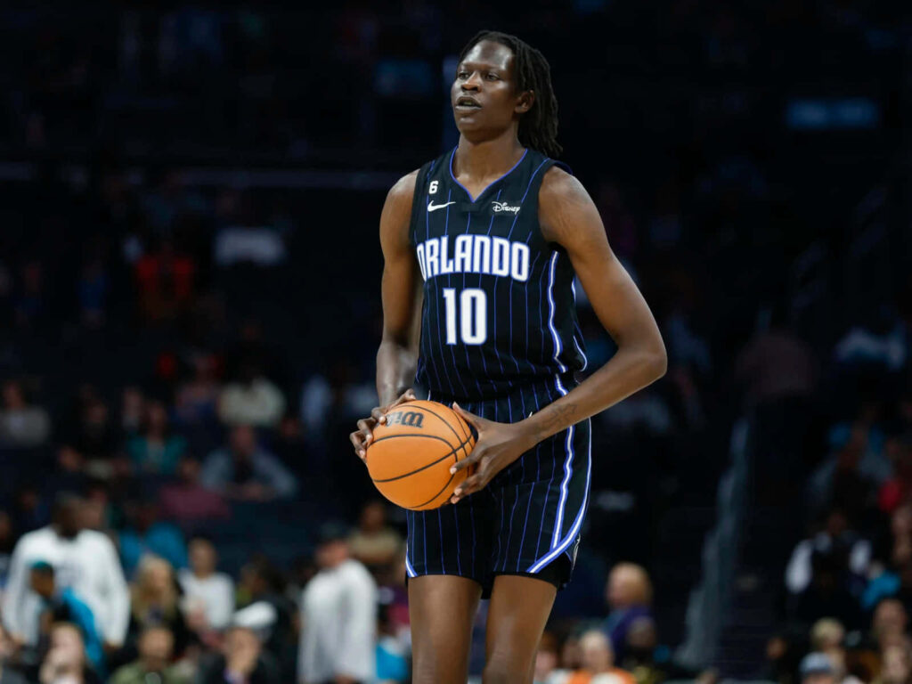 Bol Bol Orlando Magic basketball action wallpaper black pinstriped jersey vibrant arena background