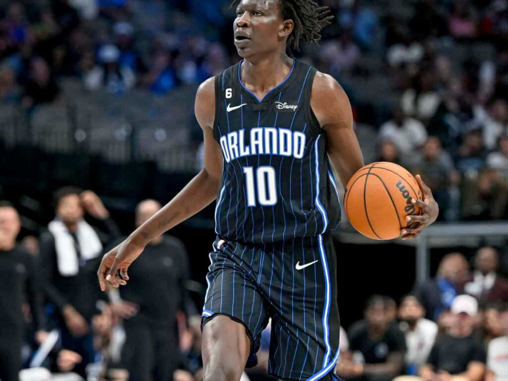 Bol Bol Orlando Magic dribbling in black blue pinstripe jersey dynamic basketball action shot Wallpaper