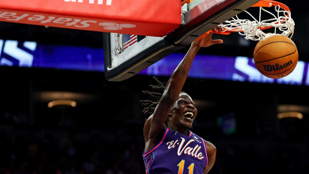 Bol Bol mid-air slam dunk action on vibrant basketball court with dynamic motion and lighting Wallpaper