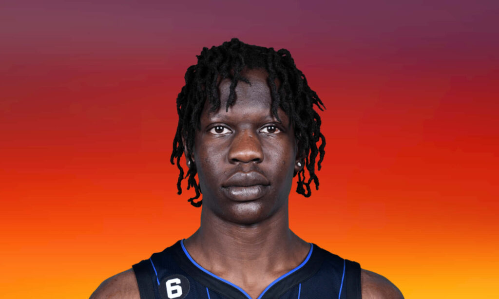 Bold close-up portrait of basketball player Bol Bol in Orlando Magic jersey with vibrant sunset background Wallpaper