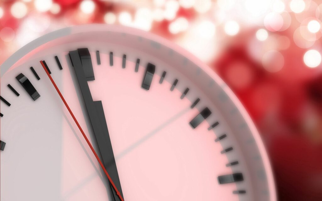 Bold Black Clock with Red Arrows - Warm Red Wallpaper Background