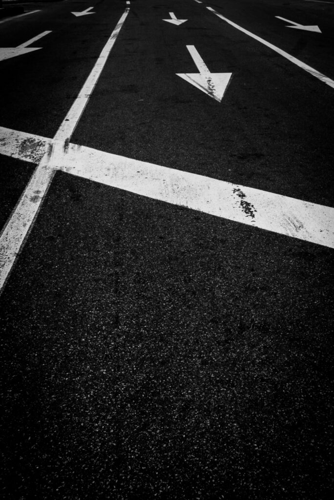 Bold Black & White Road Wallpaper: Directional Arrows on Dark Asphalt