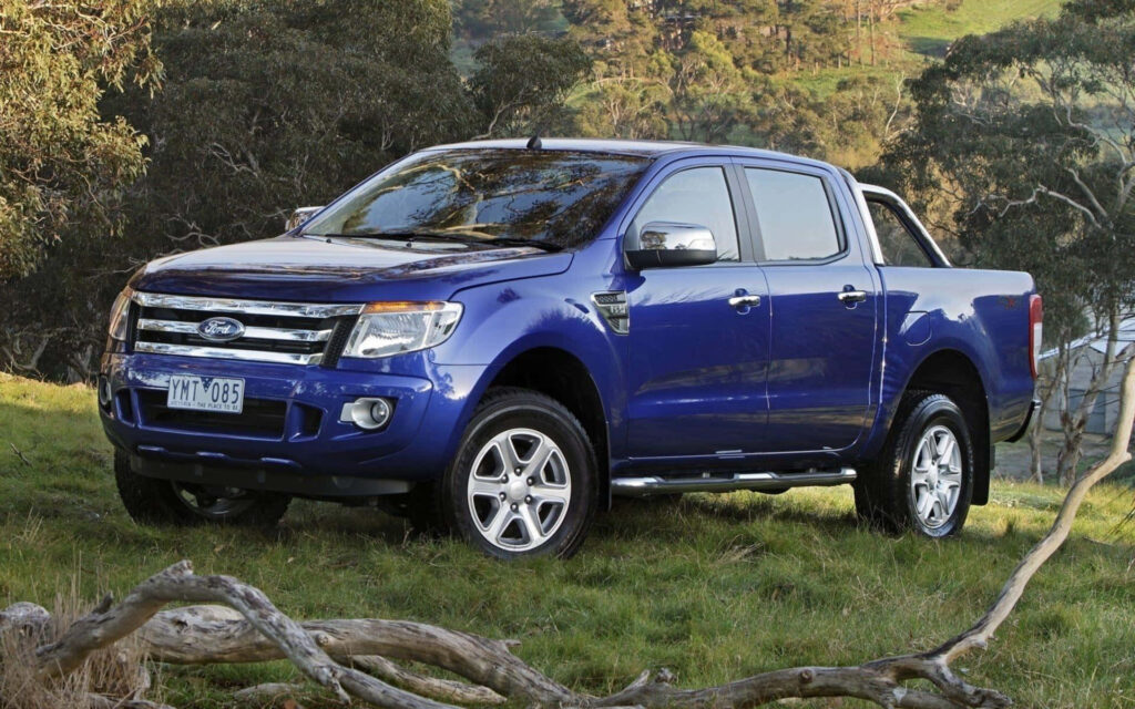 Bold blue Ford Ranger parked in scenic forest background showcasing rugged off-road capability Wallpaper