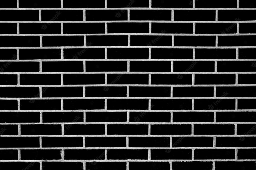Monochromatic Marvel: A Textured Black and White Brick Wall Wallpaper Set Against a Bold Background Photo
