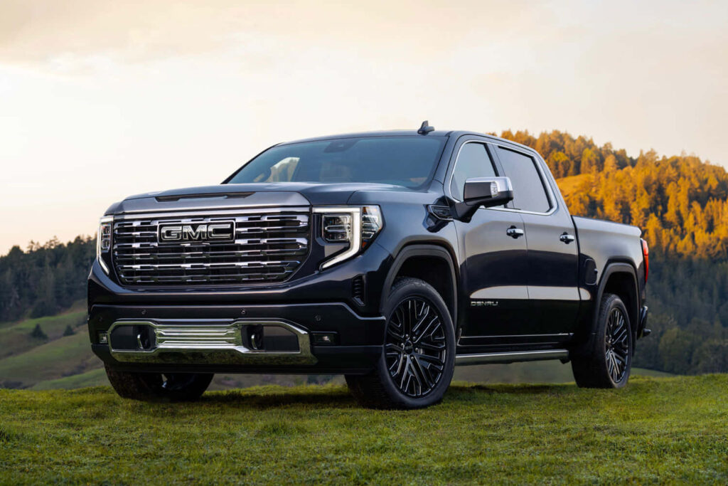 Bold GMC Sierra 1500 Wallpaper: Rugged Design on Scenic Green Terrain